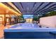 Backyard hot tub under a covered patio with views of the pool and surrounding landscaped yard at 6335 Iginlas Goal Ave, Las Vegas, NV 89131
