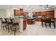 Open kitchen features granite countertops, wood cabinets, stainless appliances, and a tile floor at 6335 Iginlas Goal Ave, Las Vegas, NV 89131