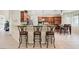 Gourmet kitchen with granite counters, stainless steel appliances, tile floors, and breakfast bar seating at 6335 Iginlas Goal Ave, Las Vegas, NV 89131