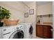 Well-equipped laundry room with modern appliances, storage cabinets and a decorative shelf at 6335 Iginlas Goal Ave, Las Vegas, NV 89131