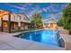 Sparkling swimming pool with waterfall features, surrounded by lush greenery and a covered patio at 6335 Iginlas Goal Ave, Las Vegas, NV 89131