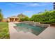 Beautiful swimming pool with tiered waterfalls, greenery, and a building with double doors in the backyard at 6335 Iginlas Goal Ave, Las Vegas, NV 89131