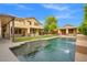 Inviting pool with a water feature and covered patio is surrounded by a lush green lawn at 6335 Iginlas Goal Ave, Las Vegas, NV 89131