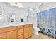 Bathroom featuring double sink vanity with framed mirror and shower with stylish blue shower curtain at 637 Taliput Palm Pl, Henderson, NV 89011