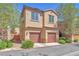 Two-story home with attached two-car garage, manicured landscaping, and desert foliage at 637 Taliput Palm Pl, Henderson, NV 89011