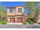 Two-story home with attached two-car garage, manicured landscaping, and desert foliage at 637 Taliput Palm Pl, Henderson, NV 89011