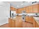 Contemporary kitchen with stainless steel appliances, wooden cabinets and granite countertop island at 637 Taliput Palm Pl, Henderson, NV 89011
