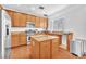 Modern kitchen features stainless appliances, wood cabinets and a center island with granite countertops at 637 Taliput Palm Pl, Henderson, NV 89011