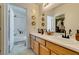 Bright bathroom featuring double sinks, wood cabinets, decorative mirrors, and shower-tub combination at 6576 Buster Brown Ave # 101, Las Vegas, NV 89122