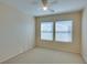 This bedroom features neutral walls, carpet flooring, two windows, and a ceiling fan at 6576 Buster Brown Ave # 101, Las Vegas, NV 89122