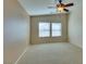 This bedroom features neutral walls, carpet flooring, two windows, and a ceiling fan at 6576 Buster Brown Ave # 101, Las Vegas, NV 89122