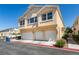 The building exterior showcases a three-car garage, neat yard, and a light beige facade at 6576 Buster Brown Ave # 101, Las Vegas, NV 89122