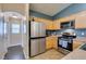 Well-lit kitchen with stainless appliances, light wood cabinets, and modern fixtures at 6576 Buster Brown Ave # 101, Las Vegas, NV 89122