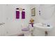 Cozy half-bathroom featuring a pedestal sink, decorative towels and toilet seat cover at 664 Foam Flower Ln, Henderson, NV 89015