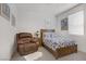 This bedroom has a bed with a wooden frame, side table, and leather chair at 664 Foam Flower Ln, Henderson, NV 89015