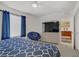 Bedroom featuring a large TV, modern dresser, and cozy blue papasan chair at 664 Foam Flower Ln, Henderson, NV 89015