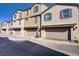 View of townhomes with garages and neutral exteriors at 664 Foam Flower Ln, Henderson, NV 89015