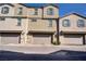 Three modern townhomes feature beige exteriors, symmetrical windows, and attached garages, offering comfortable urban living at 664 Foam Flower Ln, Henderson, NV 89015