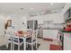 Charming kitchen with white cabinetry, stainless steel appliances, and a cozy dining table at 664 Foam Flower Ln, Henderson, NV 89015
