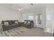Bright living room with stylish gray sofas, a modern rug, and natural light, offering a comfortable and appealing space at 664 Foam Flower Ln, Henderson, NV 89015