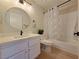 Updated bathroom features a round mirror, modern vanity, and tub/shower combo with decorative curtain at 6853 Tamarus St # 202, Las Vegas, NV 89119