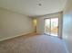 A spacious bedroom with neutral carpeting and a sliding glass door to the outdoor patio at 6853 Tamarus St # 202, Las Vegas, NV 89119
