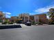 Inviting condo complex featuring covered parking, desert landscaping, and well-maintained grounds under a clear blue sky at 6853 Tamarus St # 202, Las Vegas, NV 89119