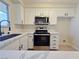 Updated kitchen with stainless steel appliances, white cabinets, and stone countertops at 6853 Tamarus St # 202, Las Vegas, NV 89119