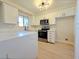 Well-lit kitchen with white cabinets, modern appliances, and a sleek countertop at 6853 Tamarus St # 202, Las Vegas, NV 89119