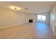 Spacious living room with light wood floors, modern fireplace, and sliding glass doors leading to a balcony at 6853 Tamarus St # 202, Las Vegas, NV 89119