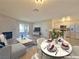Bright living room features a fireplace, light wood floors, modern decor, and a dining area at 6853 Tamarus St # 202, Las Vegas, NV 89119