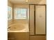 Bathroom featuring soaking tub with jets and glass enclosed shower at 7607 Pioneer Ranch Ave, Las Vegas, NV 89113