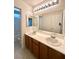 Bathroom with double sinks, wooden cabinets, and a large mirror at 7607 Pioneer Ranch Ave, Las Vegas, NV 89113