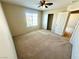 Neutral bedroom featuring carpet floors, a ceiling fan, and a window for natural light at 7607 Pioneer Ranch Ave, Las Vegas, NV 89113