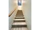 Carpeted stairs leading up to the next level with wooden railing and neutral walls at 7607 Pioneer Ranch Ave, Las Vegas, NV 89113