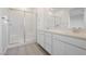 Bathroom boasts dual sinks, quartz counters, wood tile floor and shower with glass doors at 7777 Vino Vranec Ct, Las Vegas, NV 89113