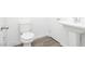 Bathroom featuring a toilet, pedestal sink, wood-look flooring, and white trim at 7777 Vino Vranec Ct, Las Vegas, NV 89113