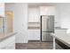 Kitchen featuring stainless steel refrigerator, white cabinets and drawers, and wood-look flooring at 7777 Vino Vranec Ct, Las Vegas, NV 89113