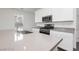 Bright kitchen features stainless steel appliances, white cabinetry, and a spacious quartz countertop island at 7777 Vino Vranec Ct, Las Vegas, NV 89113