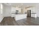 Bright modern kitchen features gray wood floors, white cabinets, stainless appliances, and a center island at 7777 Vino Vranec Ct, Las Vegas, NV 89113