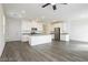 A spacious open concept kitchen and living area features gray wood floors, modern lighting, and white cabinets at 7777 Vino Vranec Ct, Las Vegas, NV 89113