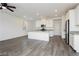 Open-concept living room with gray floors opens to the kitchen featuring white cabinets and stainless appliances at 7777 Vino Vranec Ct, Las Vegas, NV 89113