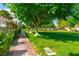 Paver walkway with manicured lawn and mature trees; view of multiple homes in the distance at 811 Spyglass Ln, Las Vegas, NV 89107