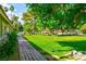 Well maintained home exterior with a lush green lawn, mature trees, and paver walkway at 811 Spyglass Ln, Las Vegas, NV 89107