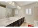 Bright bathroom featuring double sinks, a large mirror, shaker cabinets, and a shower-tub combination at 8176 Duncan Peak Ct, Las Vegas, NV 89139