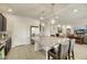 Modern kitchen with island bar stool seating and stainless steel fridge that opens into an adjacent Gathering room at 8176 Duncan Peak Ct, Las Vegas, NV 89139