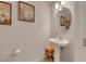 Well-lit powder room with pedestal sink and decorative wall art at 8176 Duncan Peak Ct, Las Vegas, NV 89139