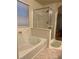 Bright bathroom featuring a soaking tub and walk-in shower with glass door at 8977 Melridge Rd, Las Vegas, NV 89148