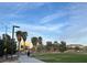 Grassy common area in a neighborhood with sidewalks, trees, and a building in the background at 8977 Melridge Rd, Las Vegas, NV 89148