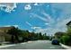 A paved neighborhood street with houses, trees, and parked cars under a blue sky at 8977 Melridge Rd, Las Vegas, NV 89148
